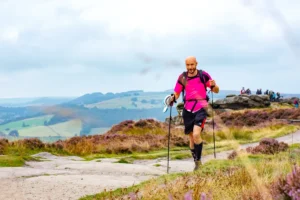 Phill running in a pink t-shirt in the Peak District